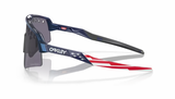 Zijaanzicht van de Oakley Sutro Lite Sweep sportbril in Troy Lee Designs Blue Colorshift met Prizm Grey Vented lens, perfect voor zonnige dagen